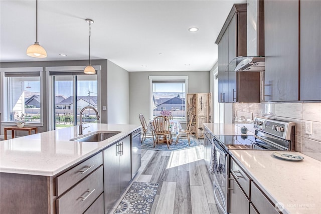 985 Spring Mountain Dr, Wenatchee, WA 98801 - kitchen with stainless steel appliances, wall chimney exhaust hood, light wood-type flooring, an island with sink, and pendant lighting