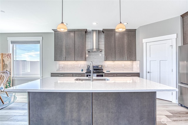 985 Spring Mountain Dr, Wenatchee, WA 98801 - kitchen with wall chimney range hood, appliances with stainless steel finishes, light wood-style flooring, backsplash, and hanging light fixtures