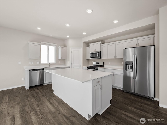 28305 74th Dr NW Unit 89, Stanwood, WA 98292 - kitchen with appliances with stainless steel finishes, a sink, dark wood-type flooring, light countertops, and a kitchen island