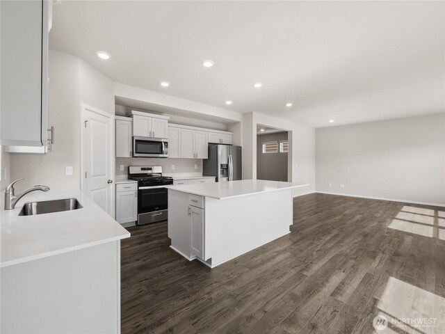 28305 74th Dr NW Unit 89, Stanwood, WA 98292 - kitchen featuring stainless steel appliances, a sink, a kitchen island, dark wood-style floors, and recessed lighting