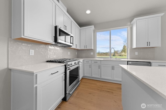 17705 11th Ave NE, Arlington, WA 98223 - kitchen with appliances with stainless steel finishes, a sink, white cabinets, light wood-style flooring, and recessed lighting