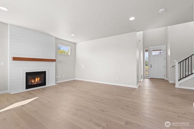 17705 11th Ave NE, Arlington, WA 98223 - unfurnished living room with light wood-style floors, baseboards, a fireplace, stairway, and recessed lighting