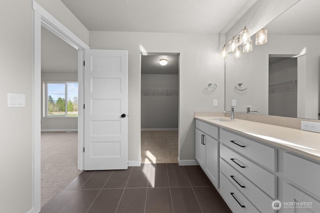17705 11th Ave NE, Arlington, WA 98223 - bathroom with vanity, a spacious closet, tile patterned floors, baseboards, and a chandelier
