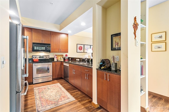 4631 Quinn Ct Unit 101, Bellingham, WA 98226 - kitchen featuring appliances with stainless steel finishes, a sink, dark countertops, brown cabinets, and dark wood-style flooring