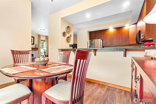 4631 Quinn Ct Unit 101, Bellingham, WA 98226 - dining room with dark wood-type flooring, a stone fireplace, and baseboards