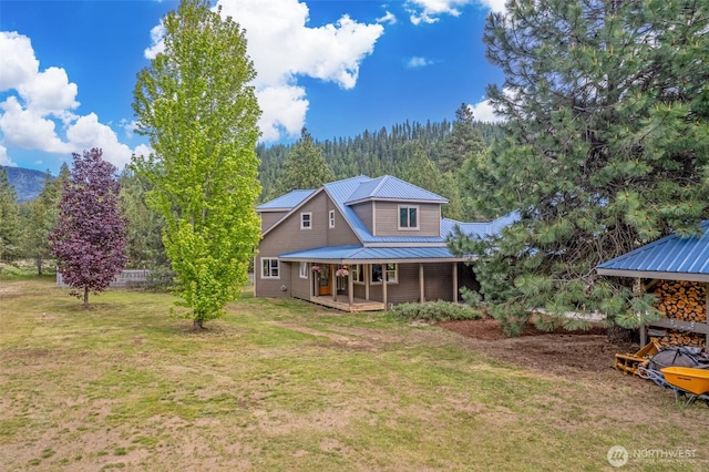 12111 W Shugart Flats Rd, Leavenworth, WA 98826 - back of house with a lawn, metal roof, covered porch, and a view of trees