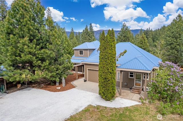 12111 W Shugart Flats Rd, Leavenworth, WA 98826 - view of front facade featuring concrete driveway, a mountain view, and metal roof
