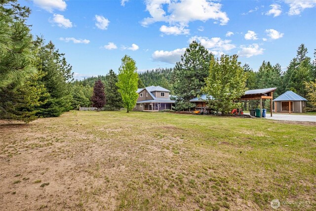 12111 W Shugart Flats Rd, Leavenworth, WA 98826 - view of grassy yard featuring a carport and a view of trees