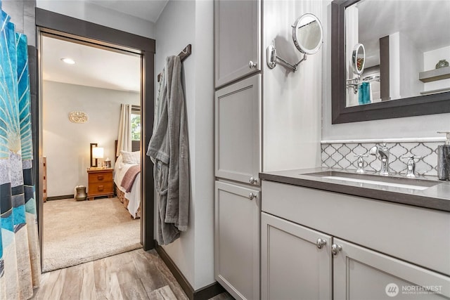 839 St Andrews Way, Bellingham, WA 98229 - full bathroom featuring decorative backsplash, vanity, ensuite bath, wood finished floors, and baseboards