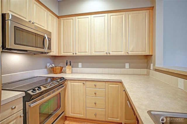13000 Admiralty Way Unit A305, Everett, WA 98204 - kitchen featuring stainless steel appliances, light brown cabinetry, and light countertops