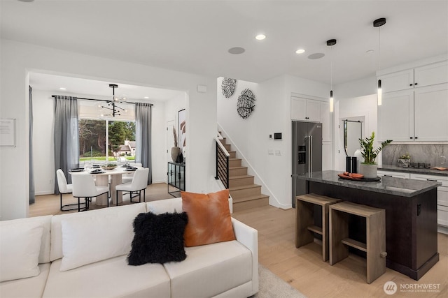 living area with stairway, recessed lighting, a chandelier, light wood-style flooring, and baseboards