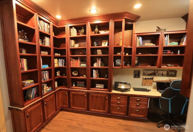 wine room with wood finished floors, built in desk, and recessed lighting