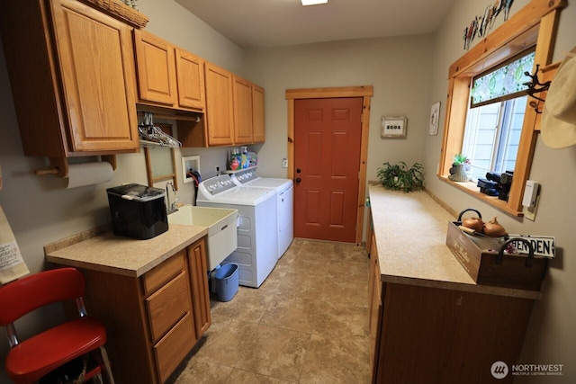 washroom featuring cabinet space and washer and clothes dryer