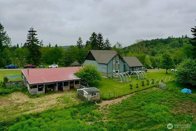 back of house with an outdoor structure and a forest view
