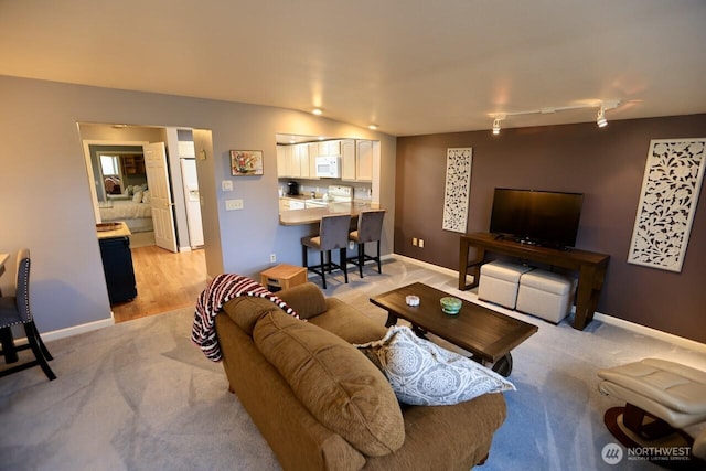 living area featuring light carpet and baseboards
