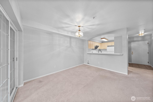 18505 SE Newport Way Unit A203, Issaquah, WA 98027 - unfurnished living room featuring light carpet, baseboards, and arched walkways