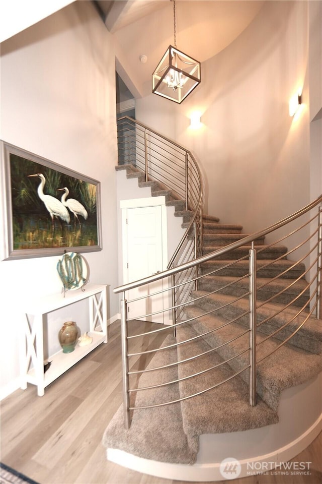 5341 S Bercot Rd, Freeland, WA 98249 - stairs featuring wood finished floors, a chandelier, and baseboards