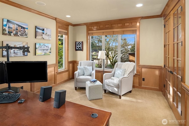 sitting room with light colored carpet, crown molding, a decorative wall, recessed lighting, and wainscoting