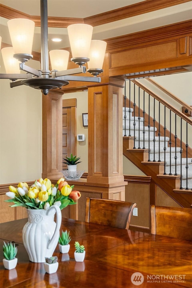 dining space with stairway, a chandelier, and ornamental molding