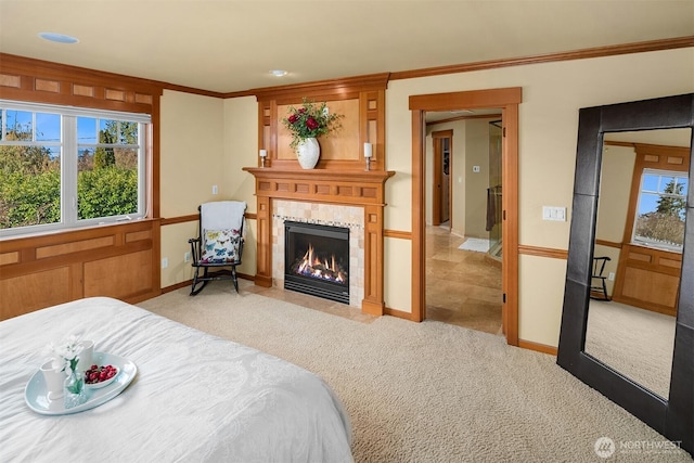 bedroom featuring light carpet, a fireplace, crown molding, and baseboards