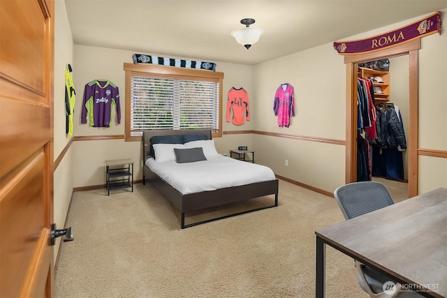 carpeted bedroom with a spacious closet, a closet, and baseboards