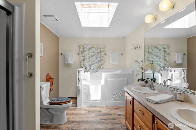 2610 E Section St Unit 115, Mount Vernon, WA 98274 - bathroom featuring a skylight, wood finished floors, a garden tub, and double vanity