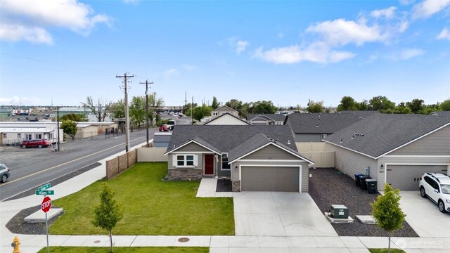 1003 NE Aspen Rd, Moses Lake, WA 98837 - view of front of property featuring an attached garage, concrete driveway, stone siding, and roof with shingles