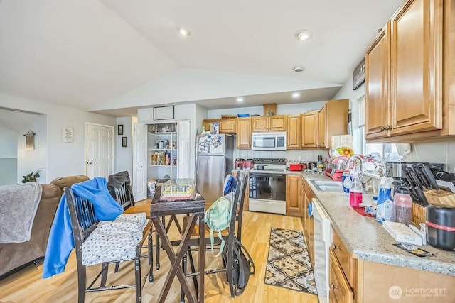 1488 Ocean Shores Blvd SW, Ocean Shores, WA 98569 - kitchen with stainless steel appliances, a sink, vaulted ceiling, light wood finished floors, and light stone counters