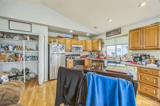1488 Ocean Shores Blvd SW, Ocean Shores, WA 98569 - kitchen featuring stainless steel appliances, lofted ceiling, light wood-style flooring, brown cabinetry, and a sink