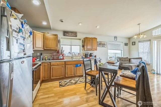 1488 Ocean Shores Blvd SW, Ocean Shores, WA 98569 - kitchen featuring freestanding refrigerator, light wood finished floors, light countertops, range with electric cooktop, and a sink