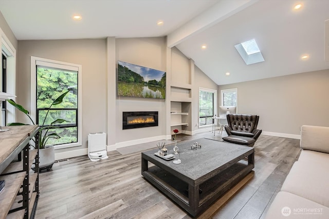 14323 SE 49th St, Bellevue, WA 98006 - living area featuring a glass covered fireplace, a skylight, wood finished floors, beamed ceiling, and baseboards