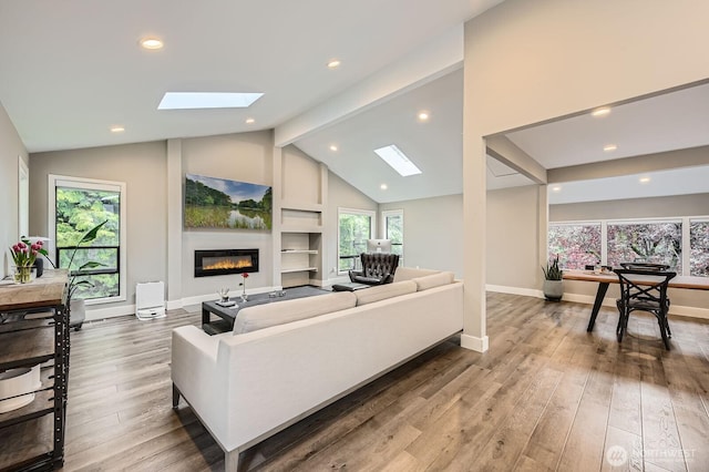 14323 SE 49th St, Bellevue, WA 98006 - living room with a skylight, a glass covered fireplace, wood finished floors, plenty of natural light, and recessed lighting