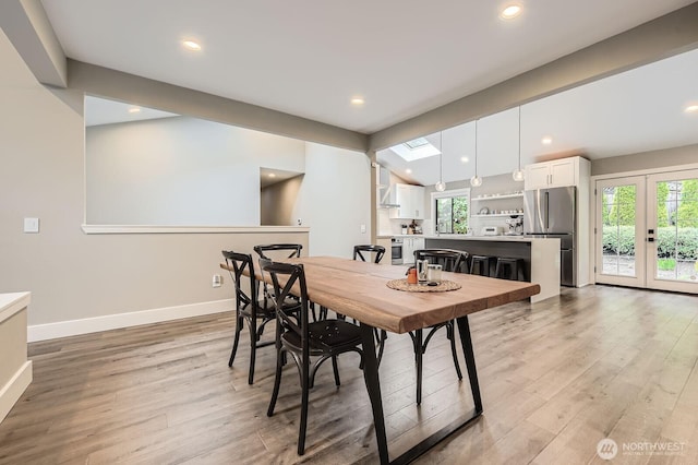 14323 SE 49th St, Bellevue, WA 98006 - dining space featuring light wood-type flooring, vaulted ceiling, baseboards, recessed lighting, and a skylight