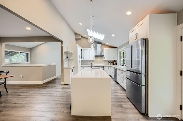 14323 SE 49th St, Bellevue, WA 98006 - kitchen with stainless steel appliances, wall chimney exhaust hood, a kitchen island with sink, light countertops, and lofted ceiling