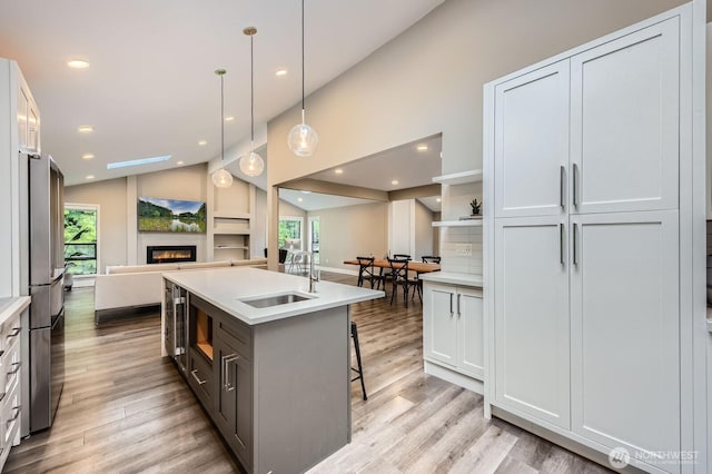14323 SE 49th St, Bellevue, WA 98006 - kitchen featuring a sink, open floor plan, lofted ceiling, plenty of natural light, and light wood-style floors