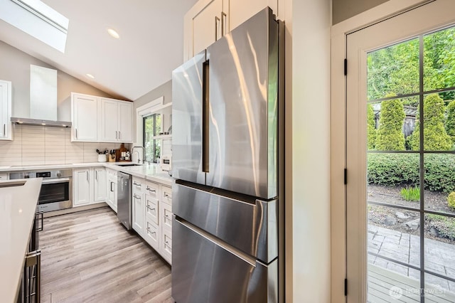 14323 SE 49th St, Bellevue, WA 98006 - kitchen featuring appliances with stainless steel finishes, a skylight, lofted ceiling, light countertops, and decorative backsplash