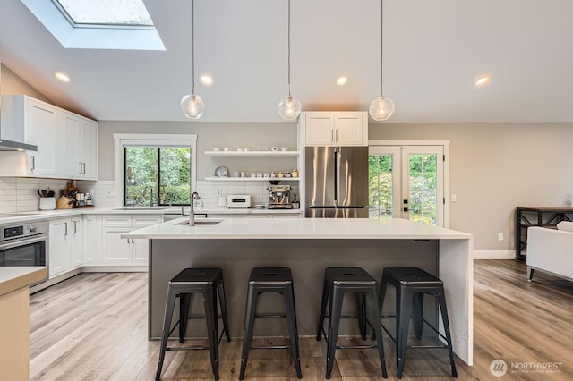 14323 SE 49th St, Bellevue, WA 98006 - kitchen with appliances with stainless steel finishes, a sink, a skylight, tasteful backsplash, and recessed lighting