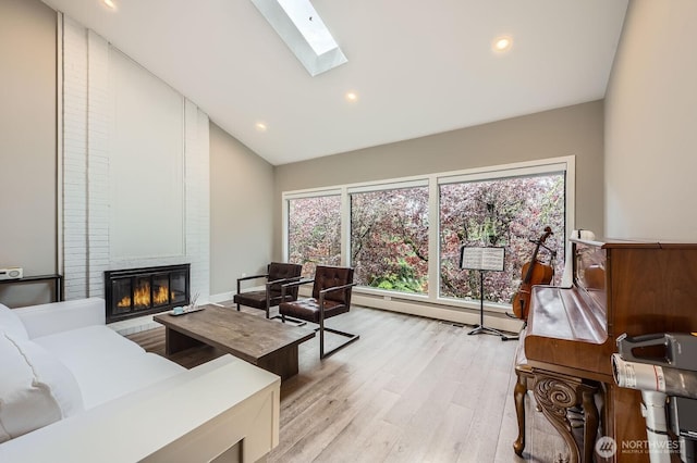 14323 SE 49th St, Bellevue, WA 98006 - living area featuring a skylight, light wood-style flooring, a brick fireplace, recessed lighting, and high vaulted ceiling