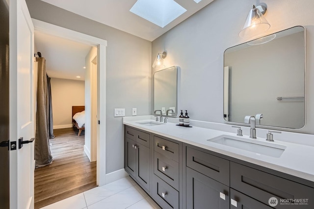 14323 SE 49th St, Bellevue, WA 98006 - ensuite bathroom featuring a skylight, double vanity, baseboards, and tile patterned floors