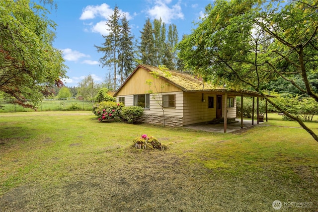view of property exterior with a lawn and a patio