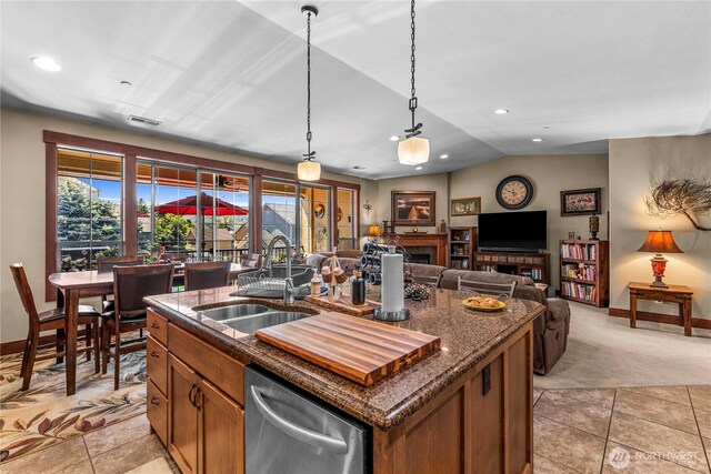 1051 N Baker Ave Unit B204, East Wenatchee, WA 98802 - kitchen with a sink, stainless steel dishwasher, brown cabinets, baseboards, and a kitchen island with sink