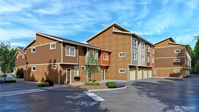 view of building exterior featuring asphalt driveway and an attached garage