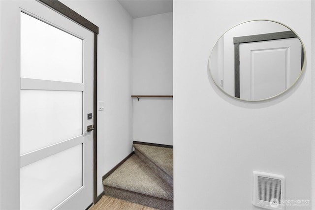 entryway with carpet floors and baseboards