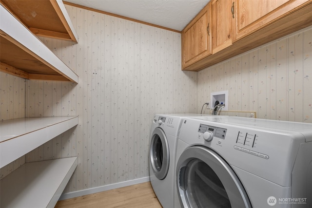260 E Tahuya Dr, Shelton, WA 98584 - washroom featuring washing machine and clothes dryer, light wood-style flooring, baseboards, cabinet space, and wallpapered walls