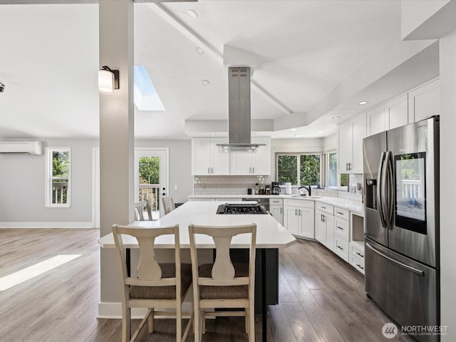 7315 294th St NE, Arlington, WA 98223 - kitchen featuring stainless steel fridge with ice dispenser, a wall mounted air conditioner, healthy amount of natural light, backsplash, and recessed lighting