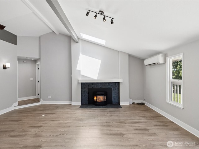 7315 294th St NE, Arlington, WA 98223 - unfurnished living room featuring a wall unit AC, light wood-type flooring, a fireplace, a skylight, and beamed ceiling