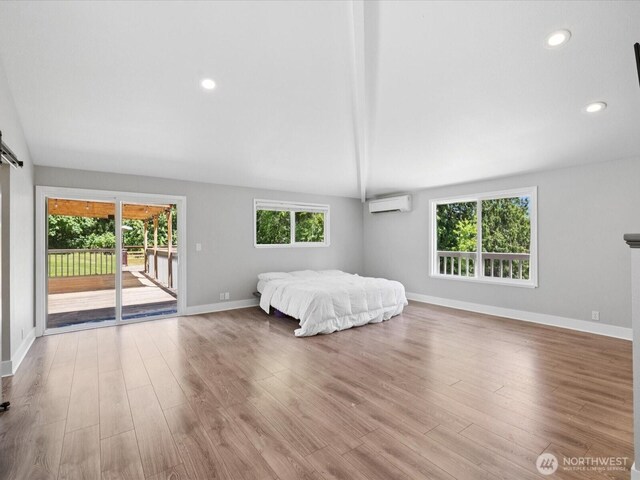 7315 294th St NE, Arlington, WA 98223 - bedroom featuring a wall mounted air conditioner, access to outside, wood finished floors, lofted ceiling, and recessed lighting
