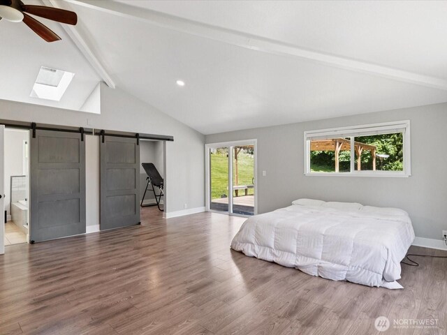 7315 294th St NE, Arlington, WA 98223 - bedroom featuring access to exterior, a barn door, wood finished floors, a skylight, and recessed lighting