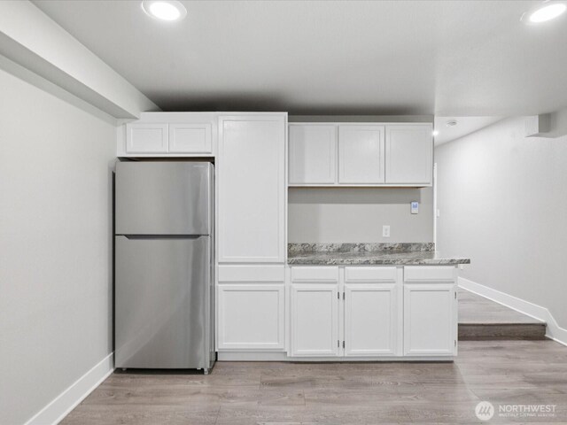 7315 294th St NE, Arlington, WA 98223 - kitchen featuring freestanding refrigerator, white cabinetry, recessed lighting, light wood-type flooring, and light stone counters