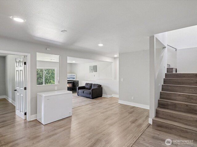 7315 294th St NE, Arlington, WA 98223 - living area featuring stairway, a warm lit fireplace, light wood-type flooring, and recessed lighting